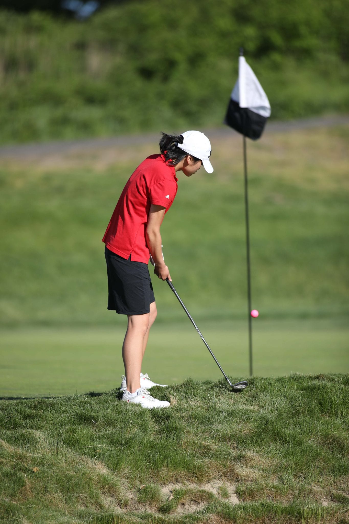 Junior Julie McAllister chips from just off the green on the third hole.