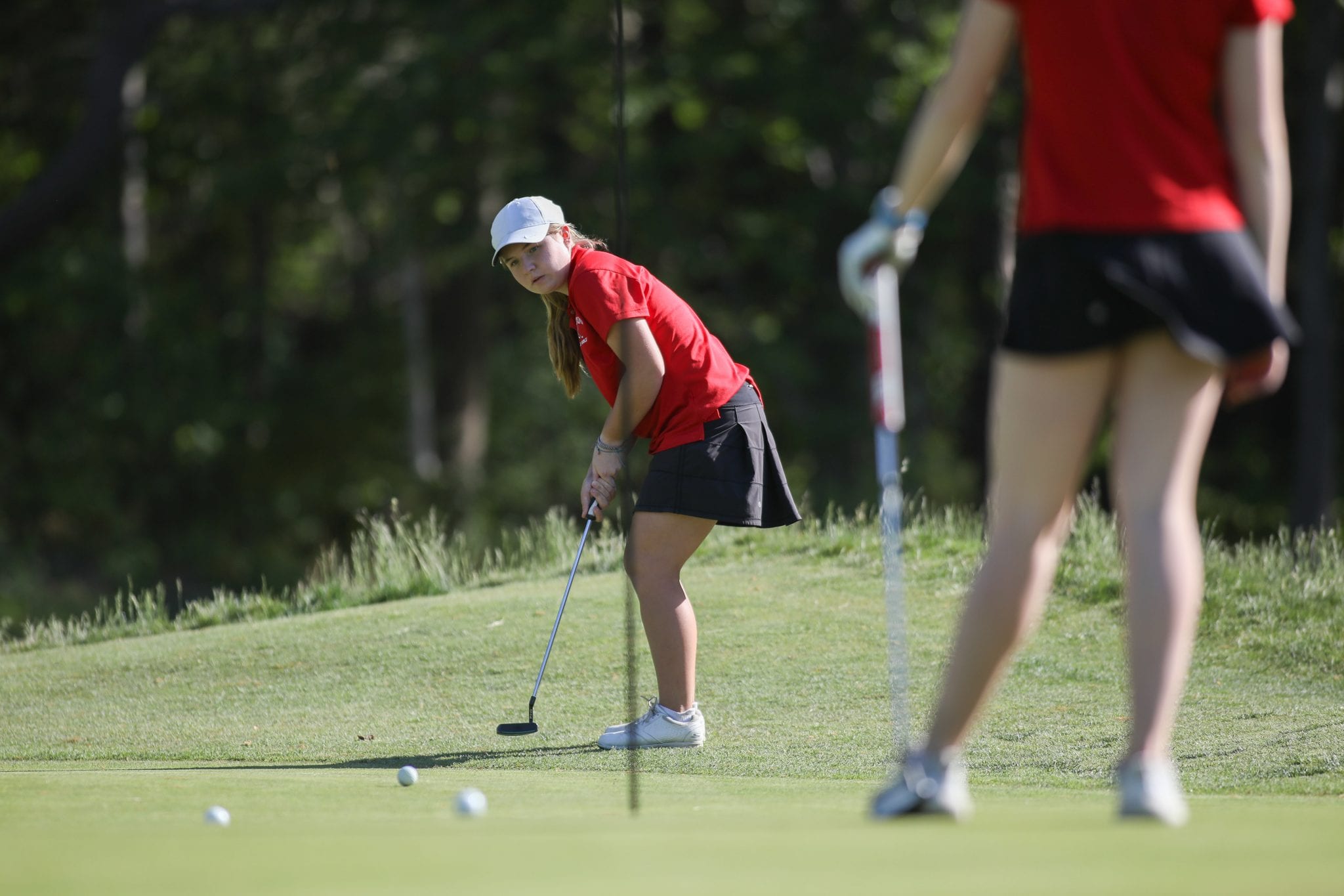 Sophomore Piper Jordan putts on the first hole.