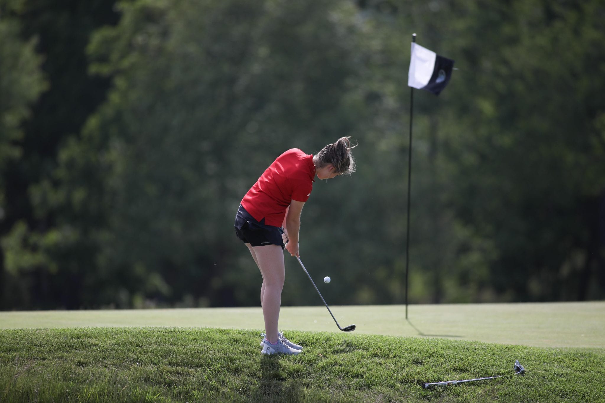 Freshman Lauren Weber chips on to the green from on the first hole. 