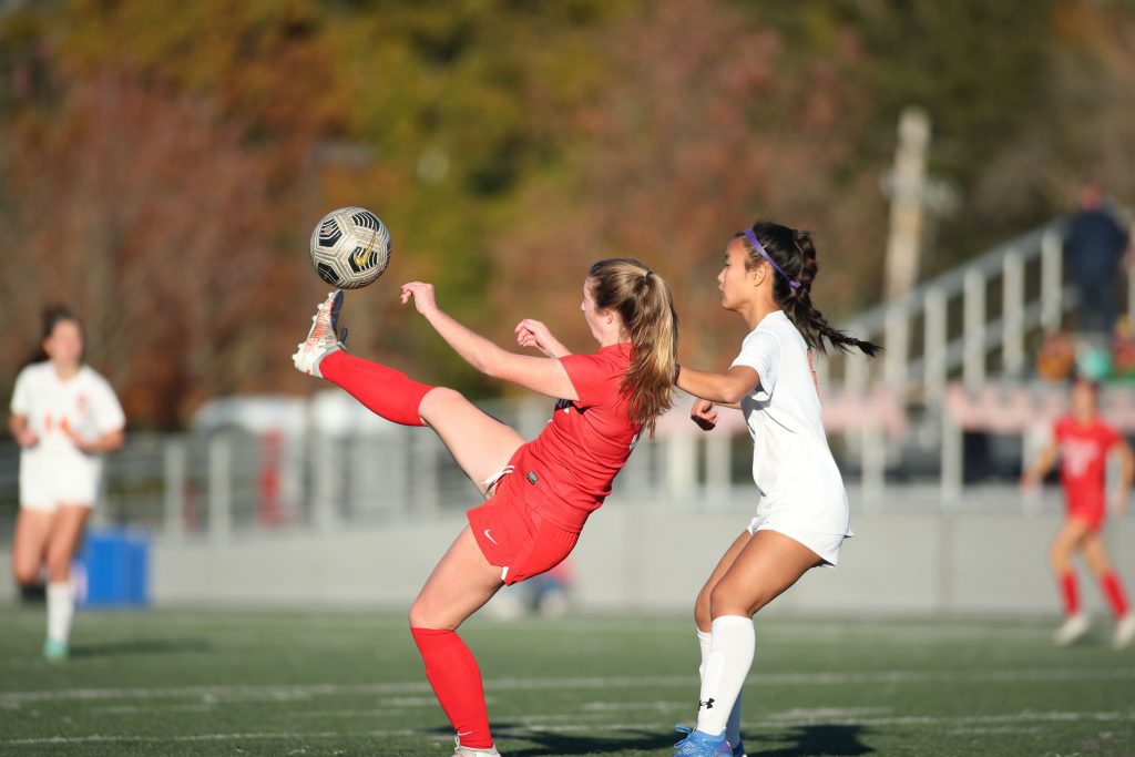 Senior captain Ava Maguire kicks the ball over her head towards the goal. 