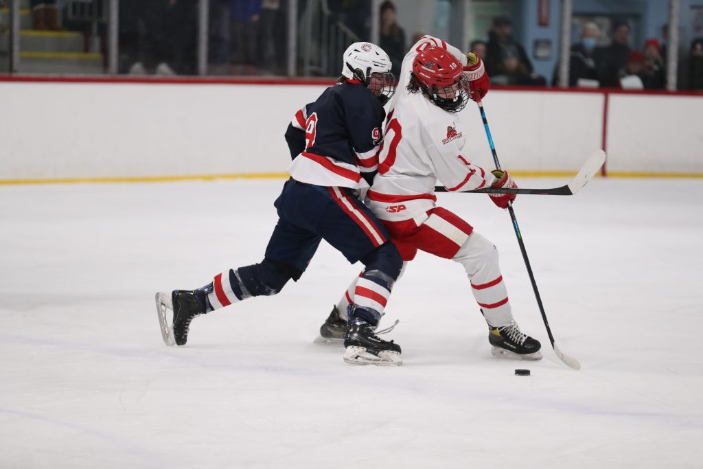 Senior captain Drew Carleton ties up with a Central Catholic player in the first period.