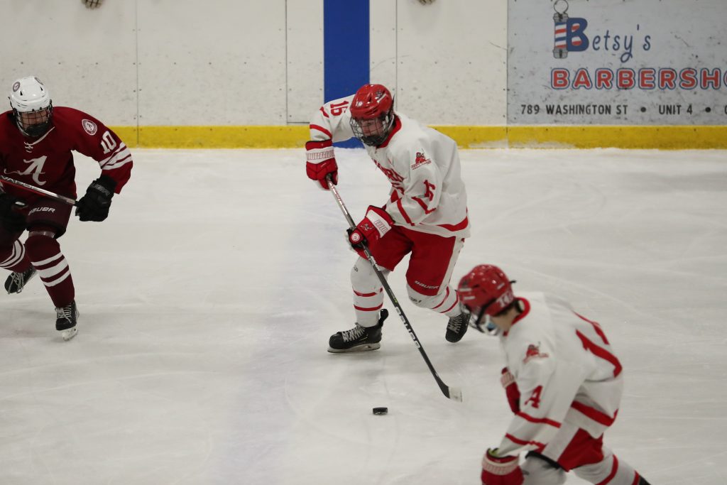 Sophomore Travis Rugg clears the puck out of his end late in the game. 