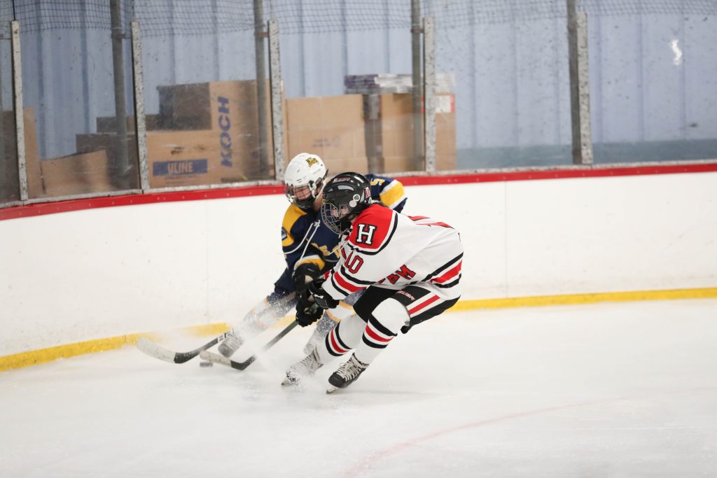 Senior Lilly Thrun races for a loose puck in the corner. 