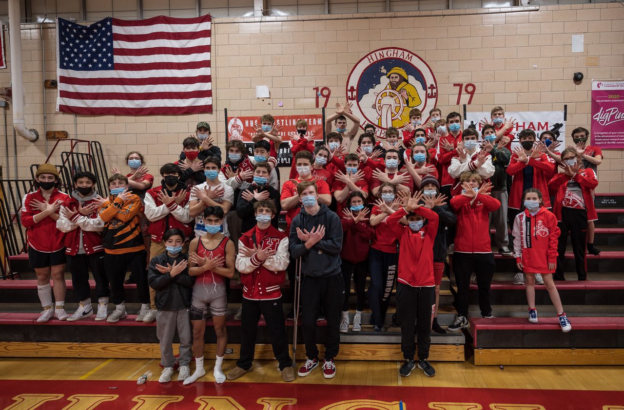 Perfect 10.  Members of the Hingham Wrestling team gesturing their most recent Patriot League title, the 10th in a row. (Photo courtesy of Fotique)