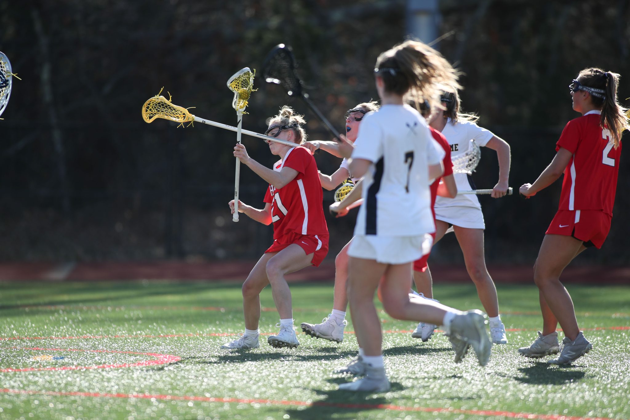 Senior captain Kenzie Wilson fights off a stick to the face and manages to score in Hingham's 17-7 loss vs NDA.