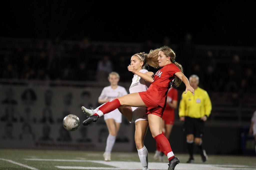 Junior Ava Varholak stretches out enough to clear the ball. 