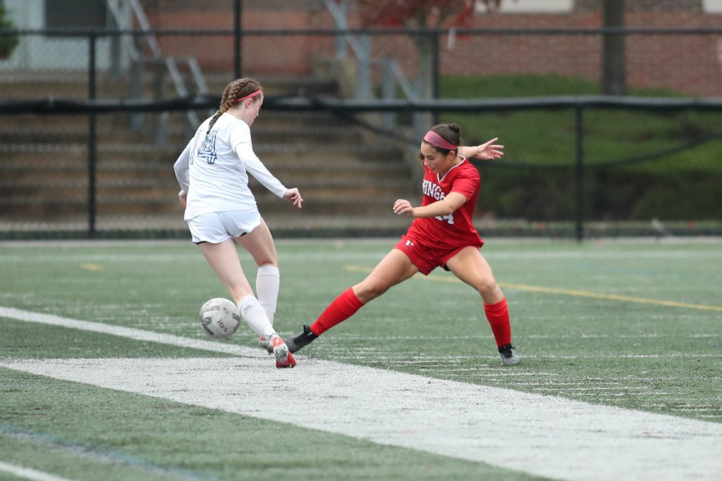 Junior Reese Pompeo pokes away the ball from a charging forward. 