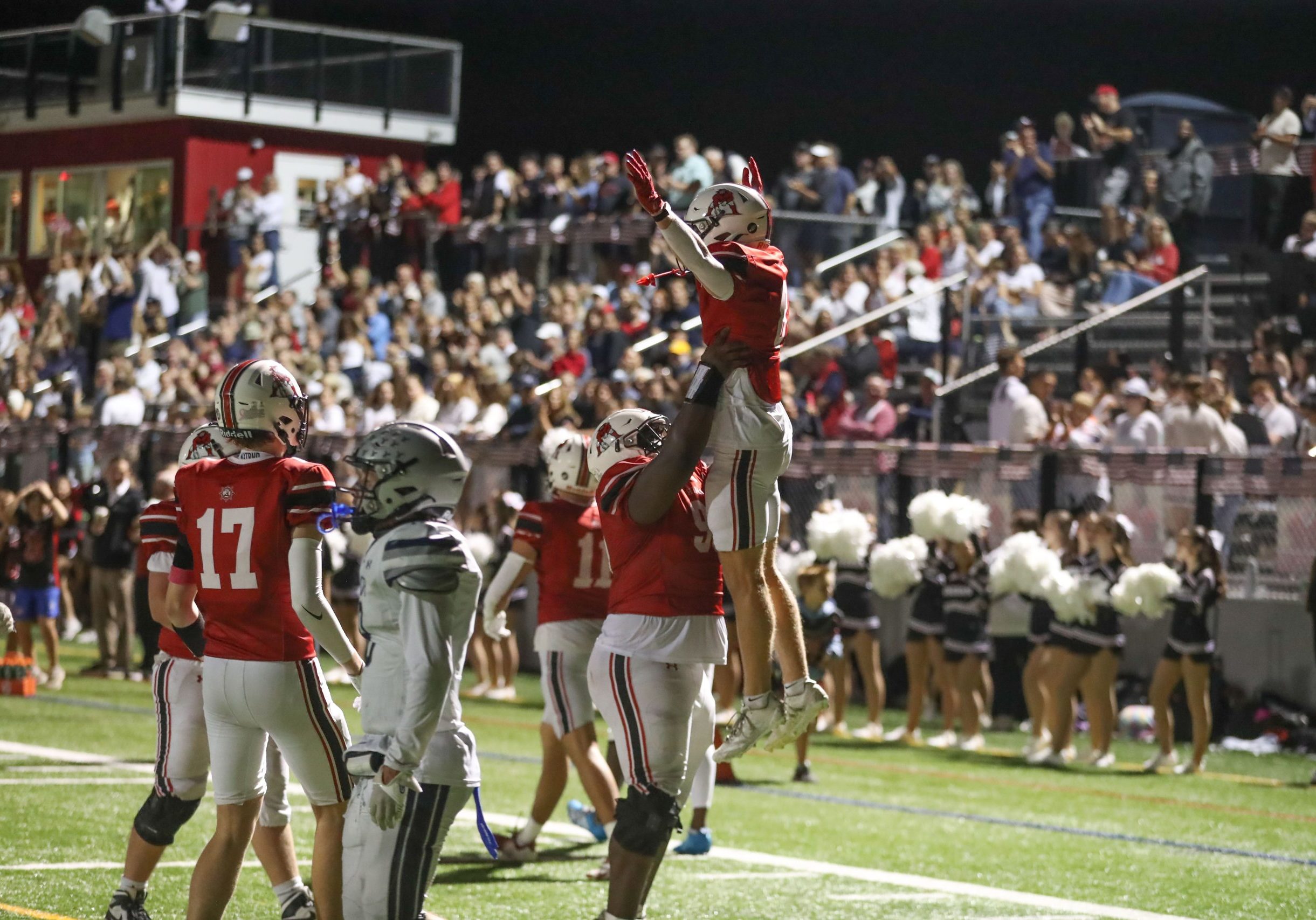 Senior captain Chris Kargbo lifts senior Ryan Kennedy into the air after Kennedy's touchdown reception in Hingham's 28-7 win over Plymouth North on Friday night. 
