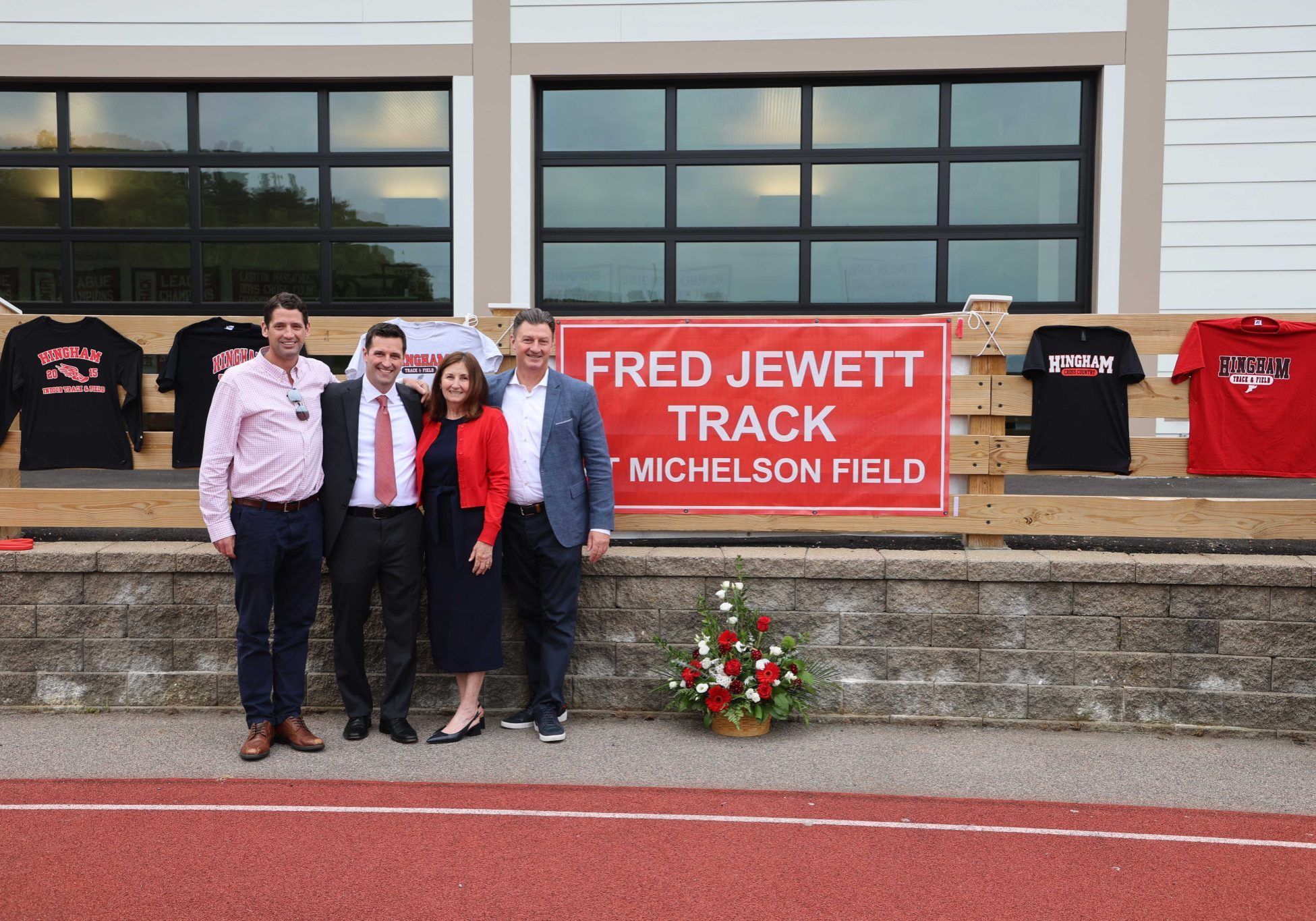 Fred Jewett's wife Rose and his three sons unveil the newly dedicated Fred Jewett Track at Hingham High School.