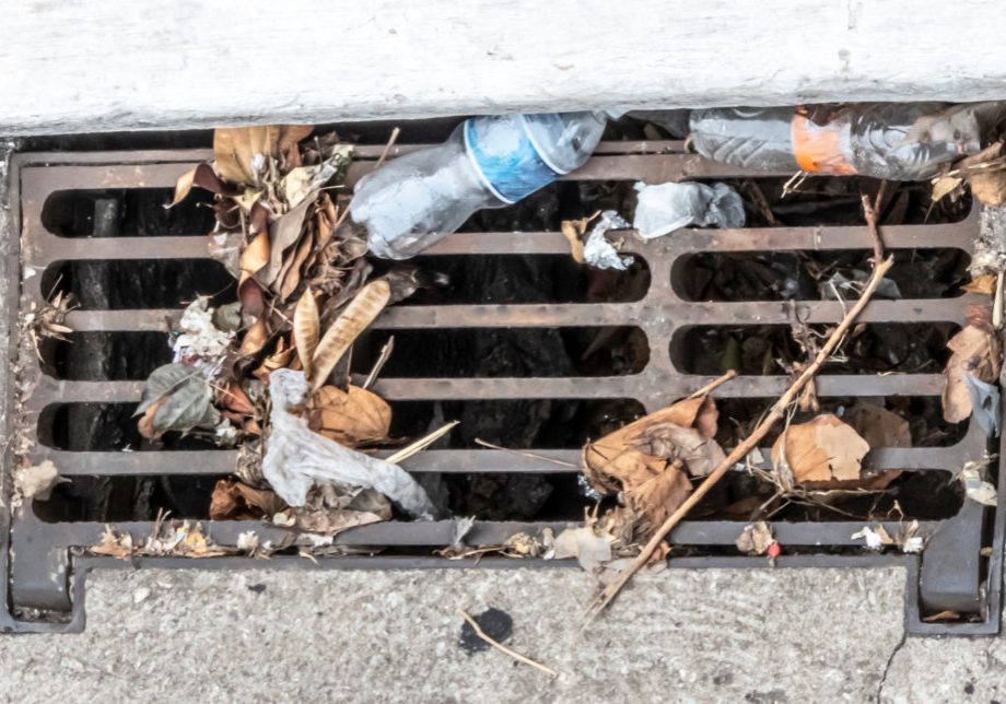 manhole with garbage next to a sidewalk in sao paulo
